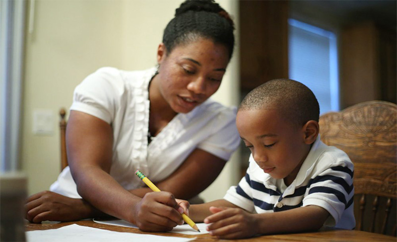 Une mère entrain d'assister son enfant à faire ses devoirs/ © espritmagazine